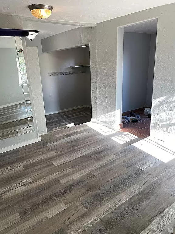 Unfurnished bedroom with dark hardwood / wood-style flooring and a closet