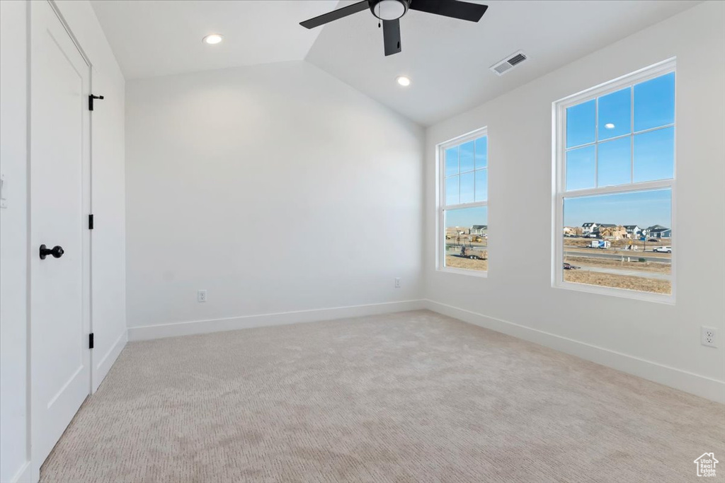Unfurnished bedroom featuring light carpet, ceiling fan, and lofted ceiling