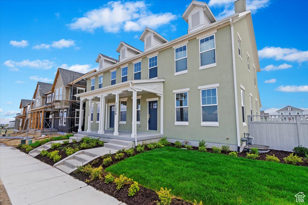 View of front of house featuring a front lawn and covered porch