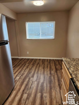 Unfurnished dining area with dark wood-type flooring