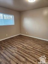 Empty room featuring dark wood-type flooring