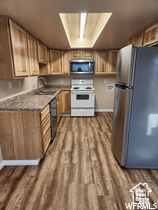 Kitchen featuring appliances with stainless steel finishes, sink, and hardwood / wood-style floors