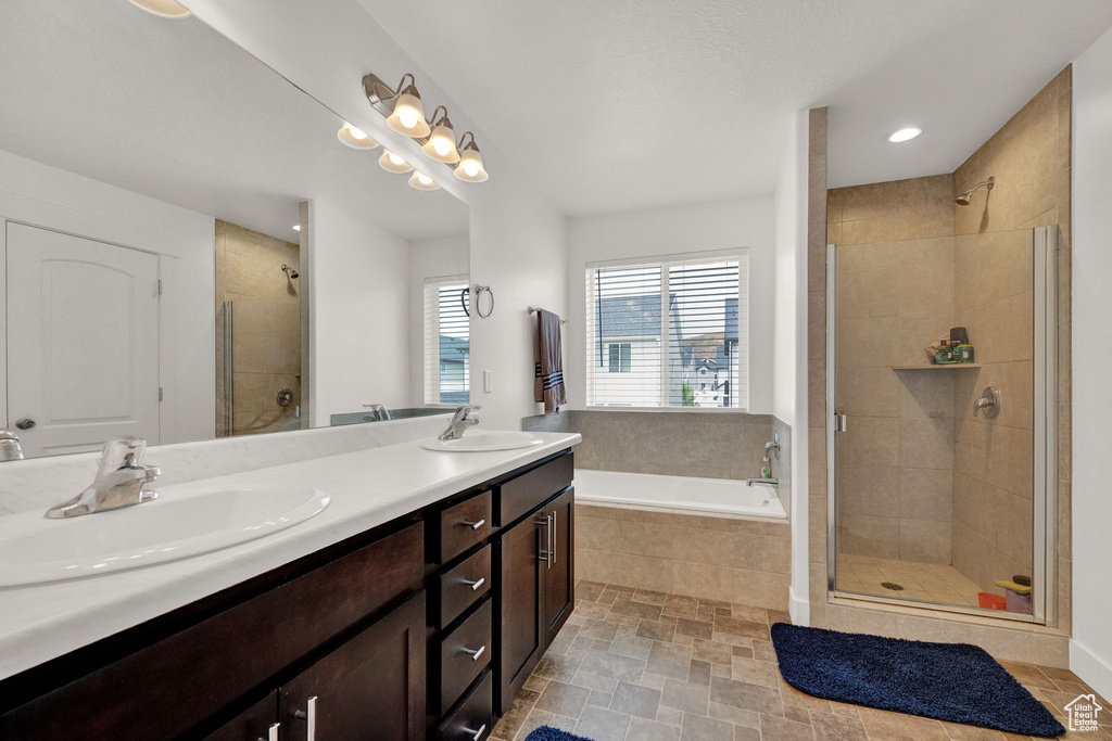 Bathroom with tile flooring, independent shower and bath, double sink, and oversized vanity