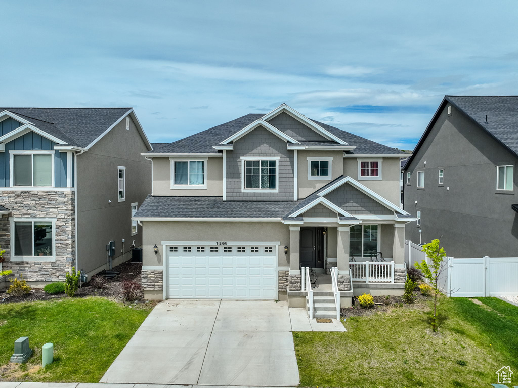 Craftsman-style house with a garage, a front yard, and covered porch