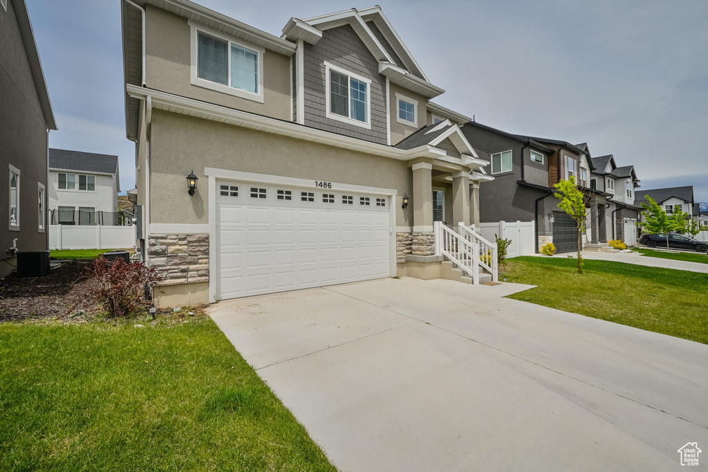 View of front of property with a garage and central AC unit