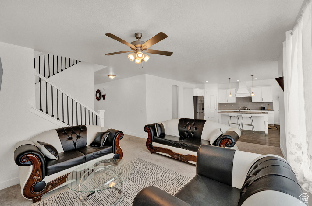 Living room with light wood-type flooring, sink, and ceiling fan