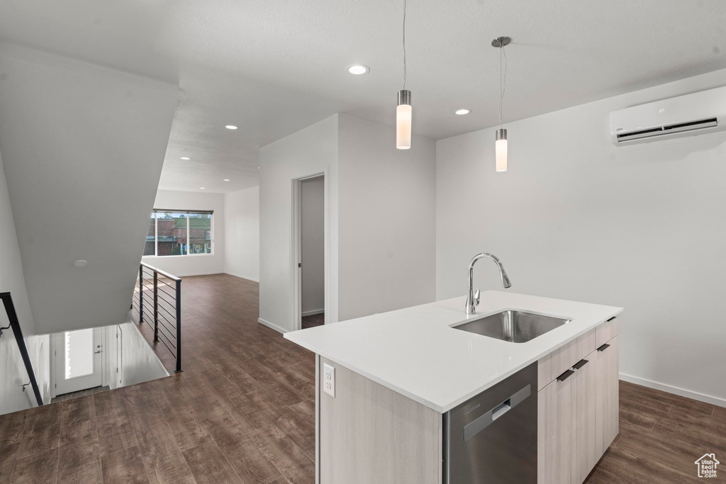 Kitchen featuring a kitchen island with sink, dark wood-type flooring, a wall mounted AC, sink, and pendant lighting