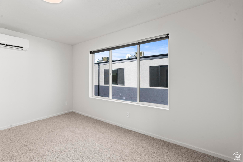 Carpeted empty room featuring a wall mounted air conditioner