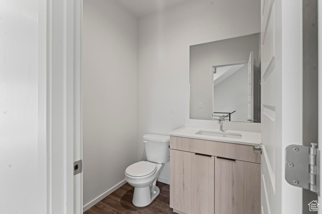 Bathroom featuring large vanity, toilet, and hardwood / wood-style floors