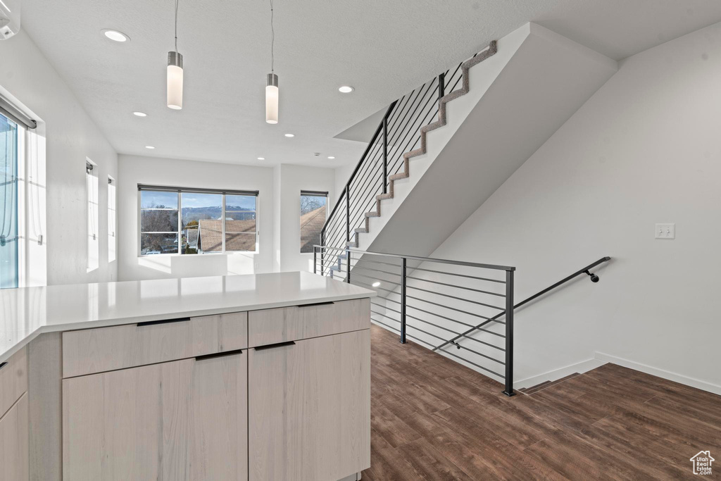 Kitchen with dark wood-type flooring and hanging light fixtures