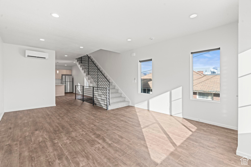 Interior space featuring hardwood / wood-style floors and an AC wall unit