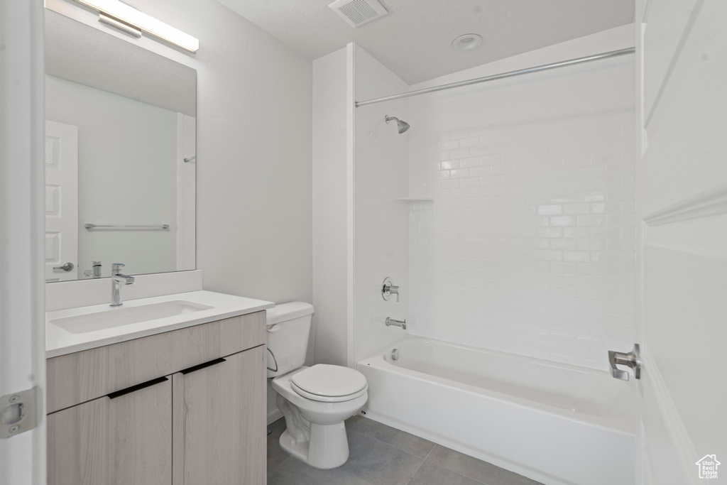 Full bathroom with tile flooring, washtub / shower combination, vanity, and toilet