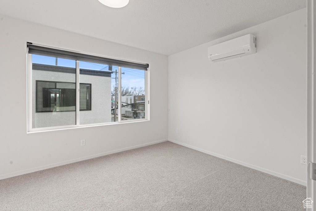 Carpeted empty room with an AC wall unit