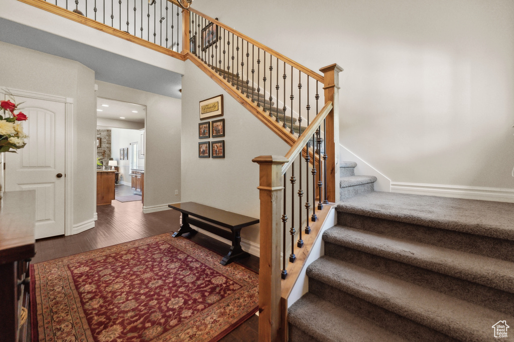 Staircase featuring dark wood-type flooring