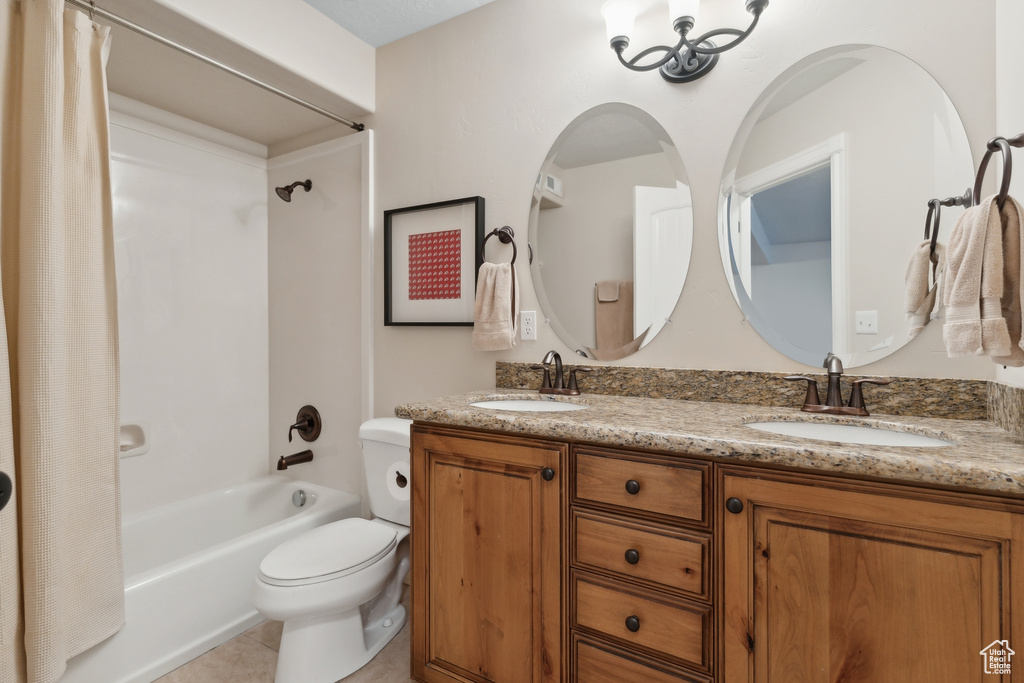 Full bathroom featuring dual bowl vanity, toilet, shower / bath combo, and tile floors