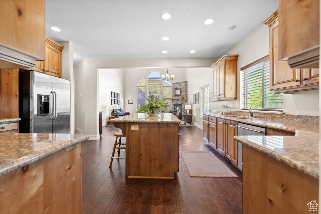 Kitchen featuring a kitchen island, dark hardwood / wood-style flooring, stainless steel appliances, a breakfast bar area, and plenty of natural light