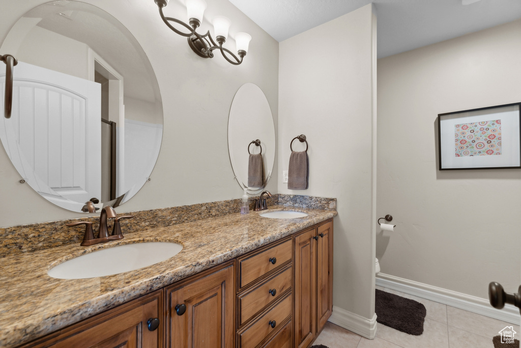 Bathroom with double vanity and tile floors