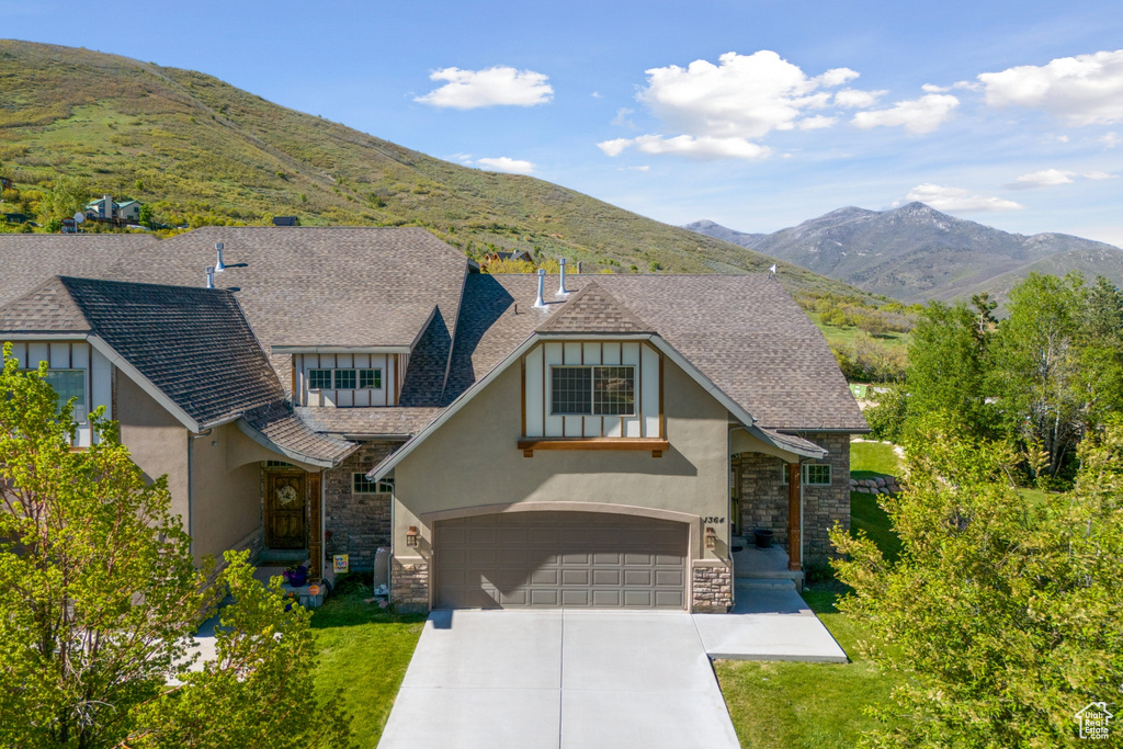 Tudor home with a garage and a mountain view