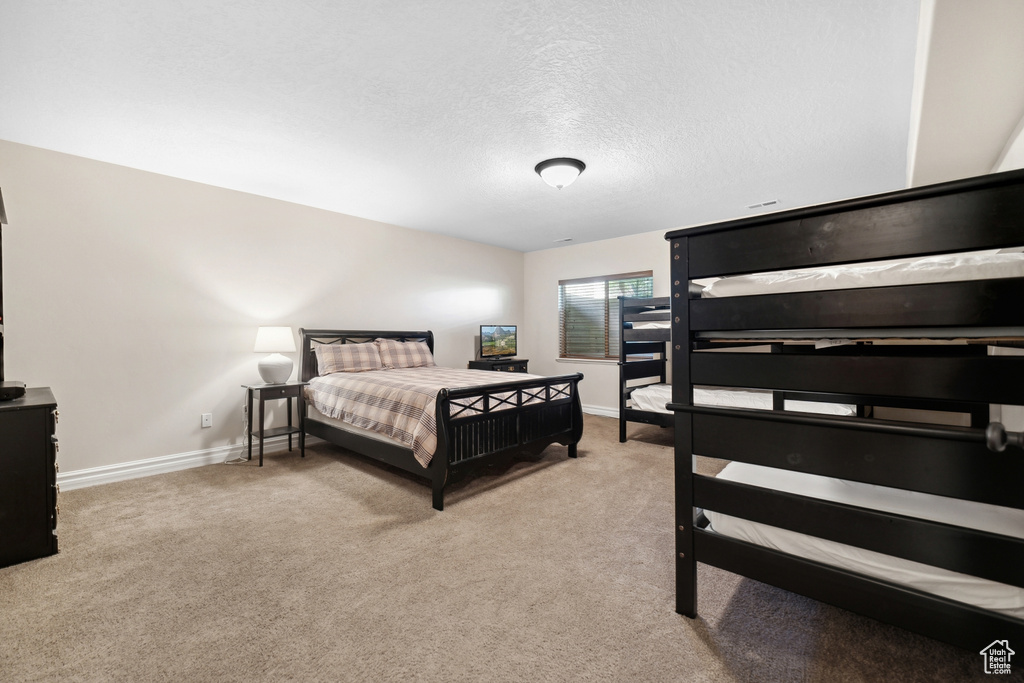 Carpeted bedroom with a textured ceiling