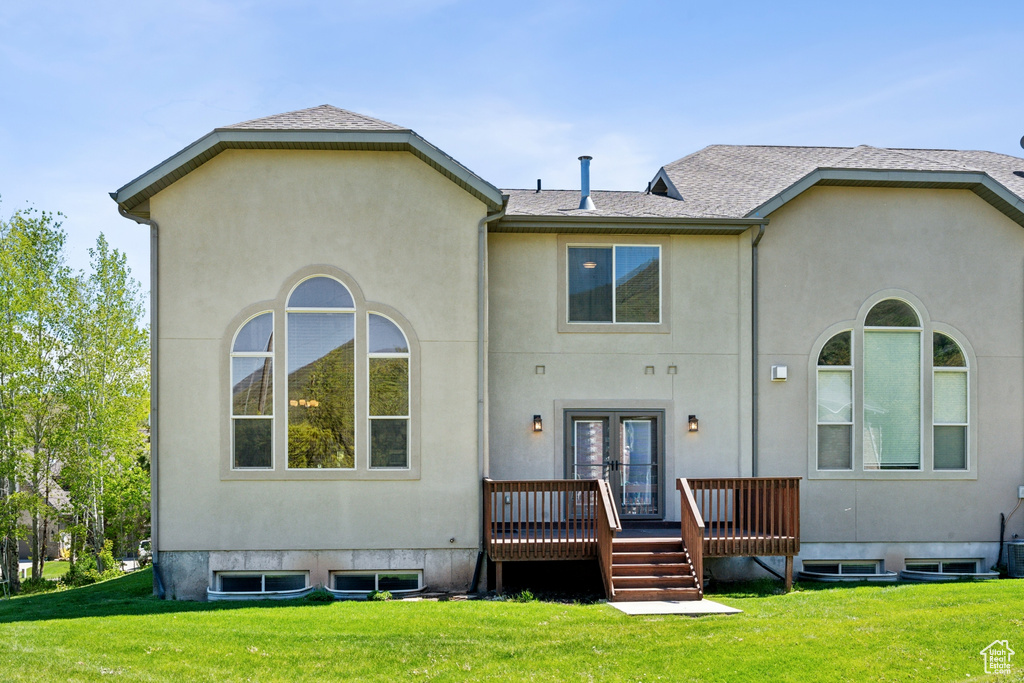 Back of property with a deck and a yard