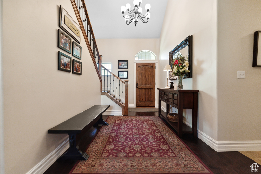 Foyer with a notable chandelier, hardwood / wood-style flooring, and high vaulted ceiling