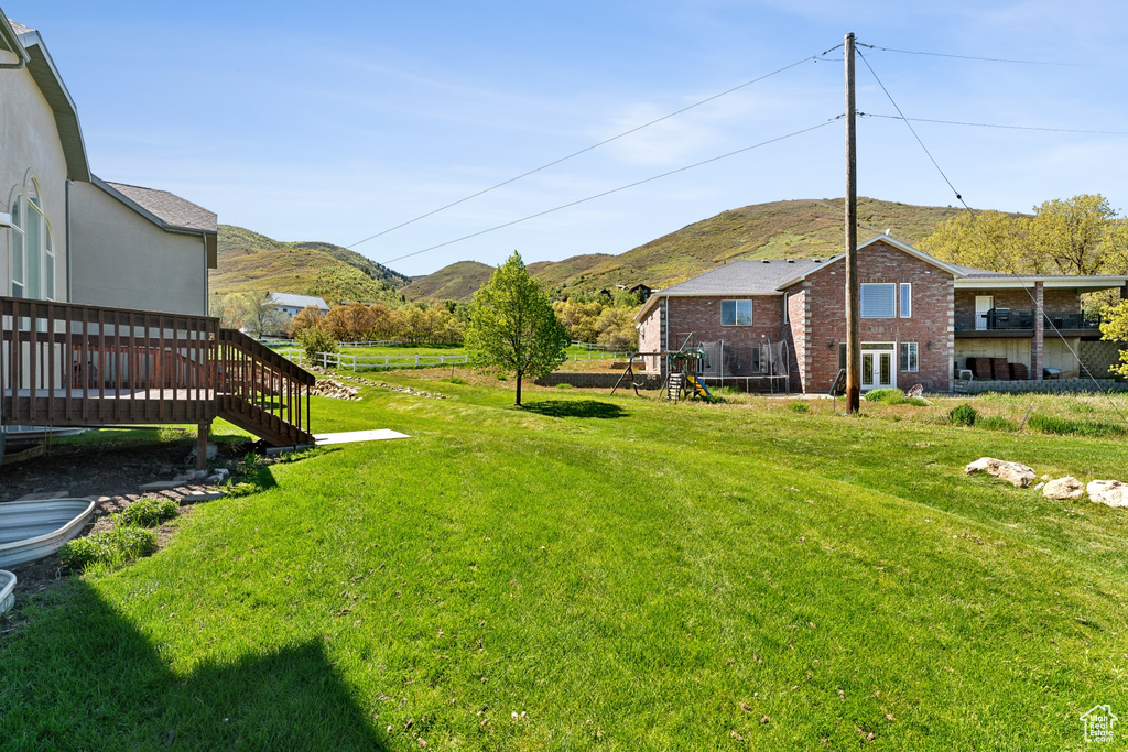 View of yard with a deck with mountain view