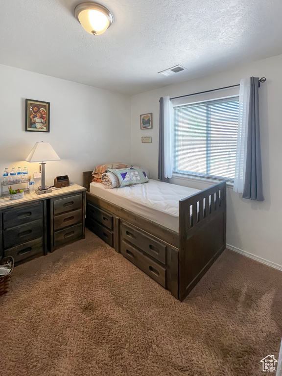 Bedroom featuring a textured ceiling and carpet flooring
