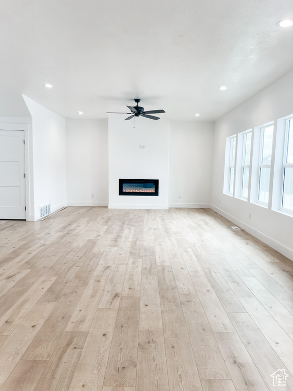 Unfurnished living room with ceiling fan and light wood-type flooring