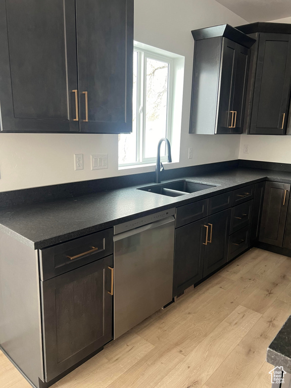 Kitchen featuring sink, stainless steel dishwasher, and light wood-type flooring