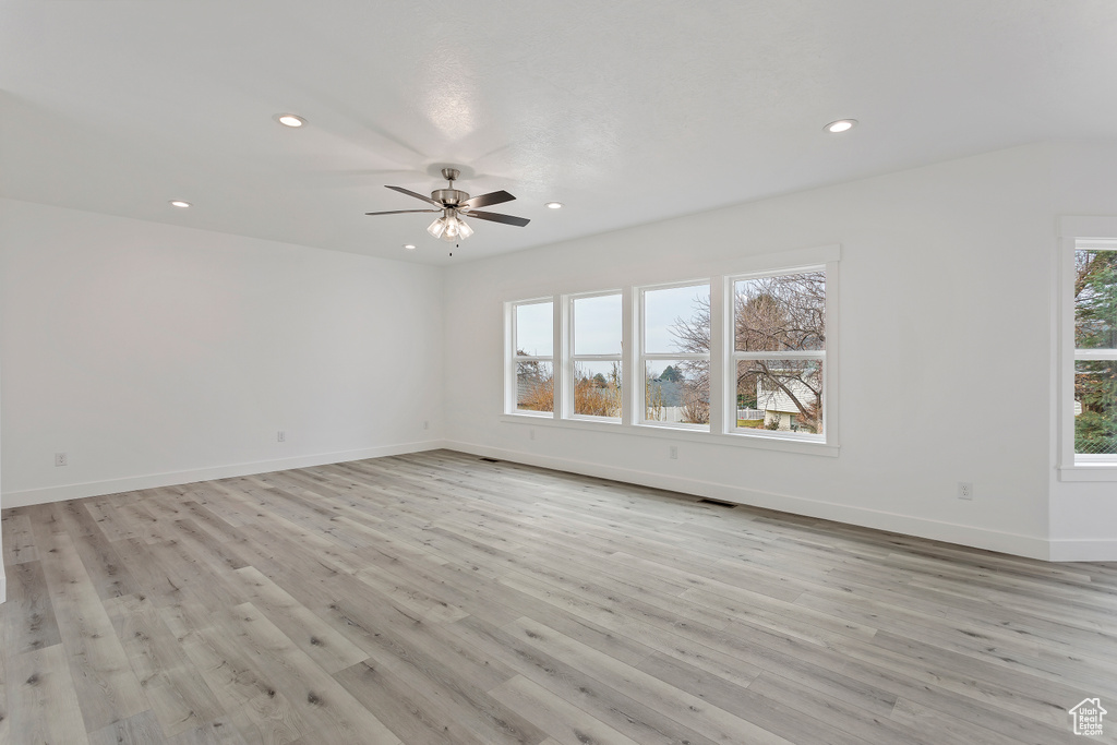 Unfurnished room featuring a wealth of natural light, ceiling fan, and light hardwood / wood-style floors