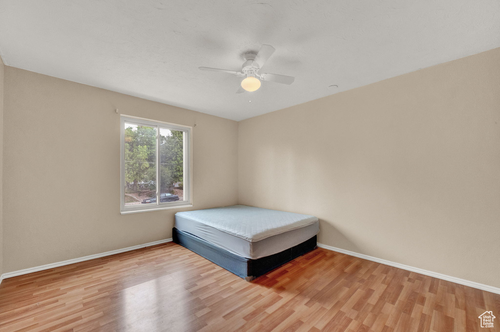 Unfurnished bedroom featuring ceiling fan and light hardwood / wood-style flooring