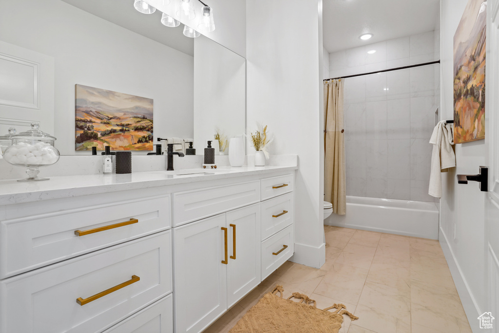 Full bathroom with tile flooring, shower / bath combination with curtain, oversized vanity, and toilet