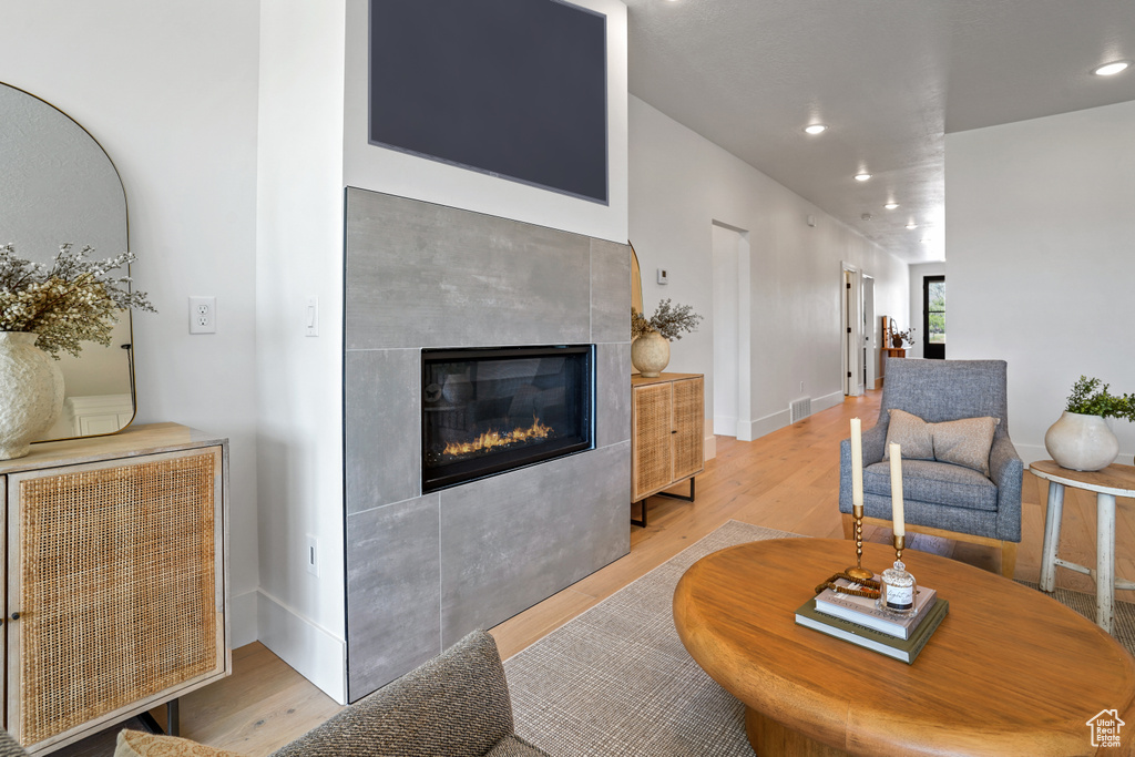 Living room featuring light hardwood / wood-style flooring and a tile fireplace