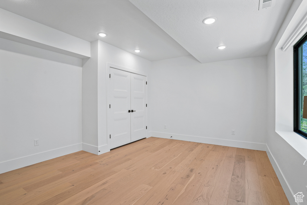 Spare room featuring a healthy amount of sunlight and light wood-type flooring