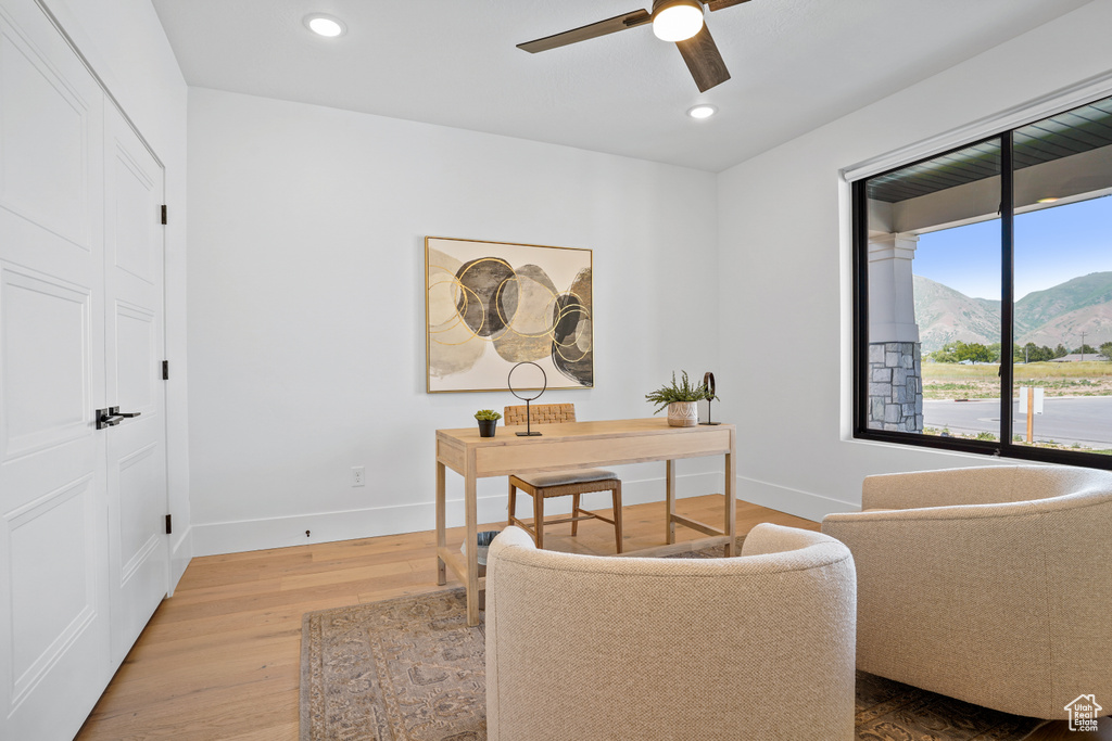 Home office featuring ceiling fan, a mountain view, and wood-type flooring