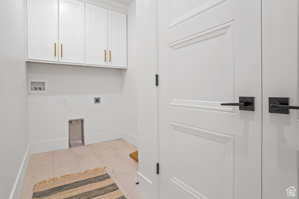 Washroom featuring hookup for a washing machine, hookup for an electric dryer, cabinets, and light tile floors