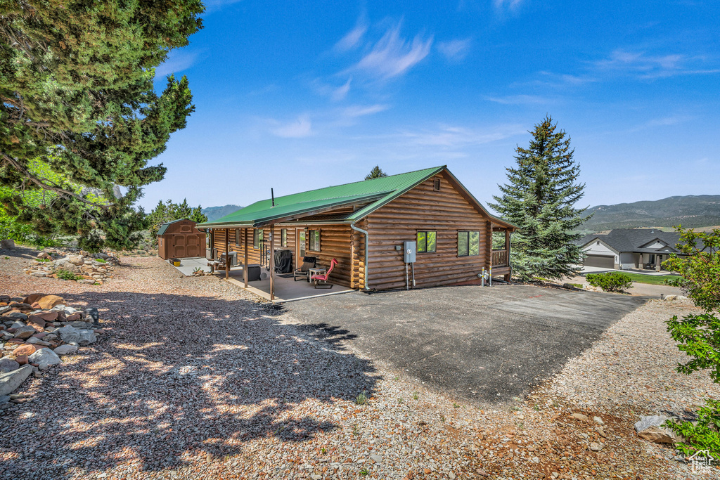 Rear view of property with a storage unit