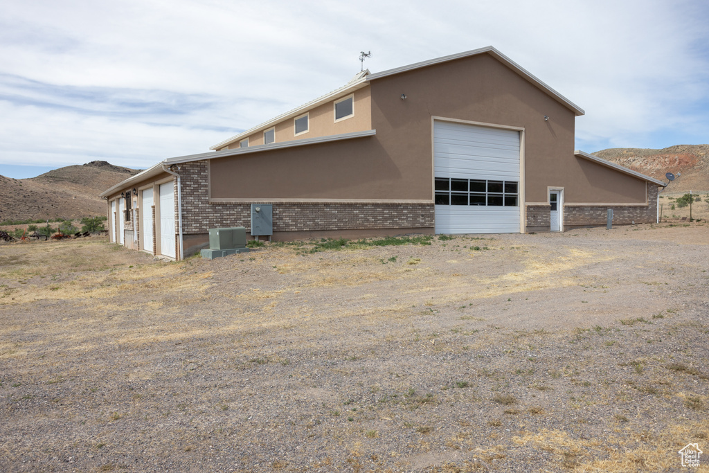 Rear view of property with a garage and a mountain view