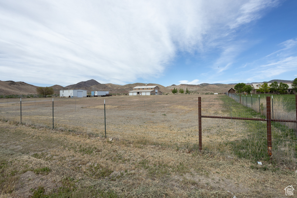 View of yard with a rural view, a garage, and a mountain view