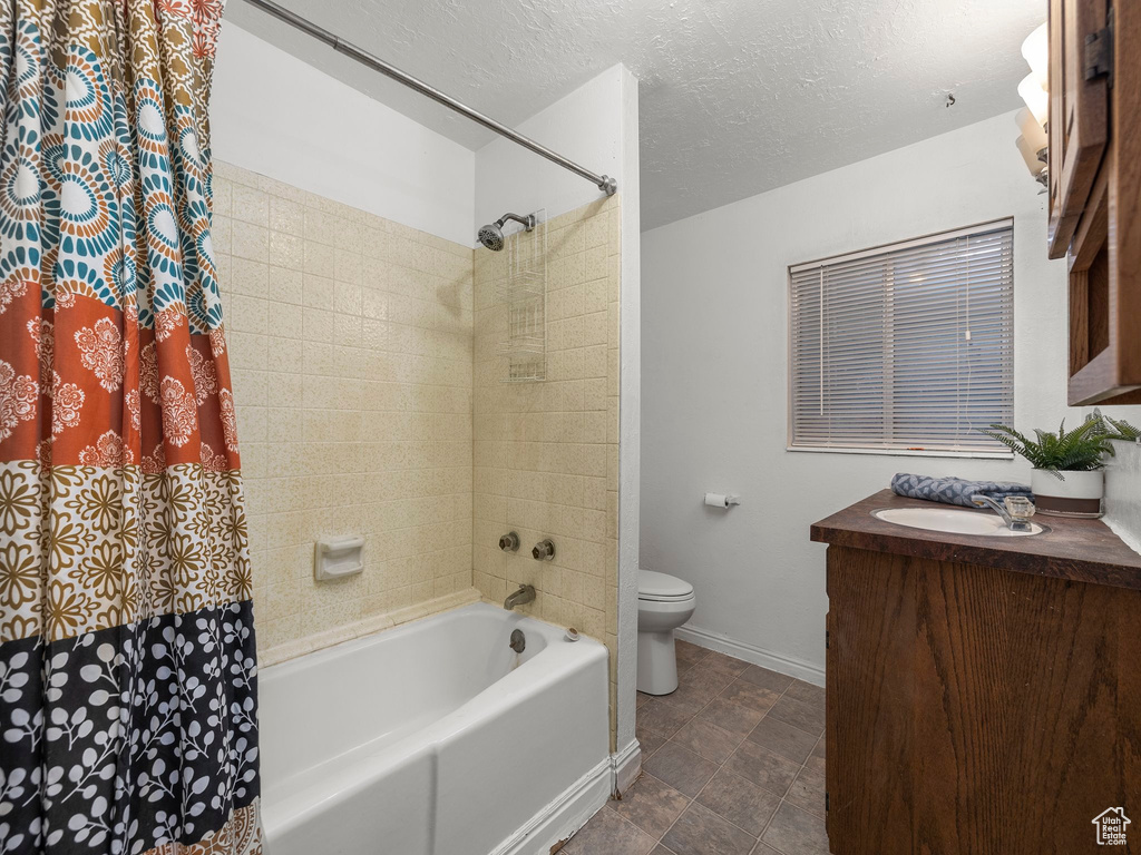 Full bathroom with tile floors, shower / tub combo, toilet, and vanity