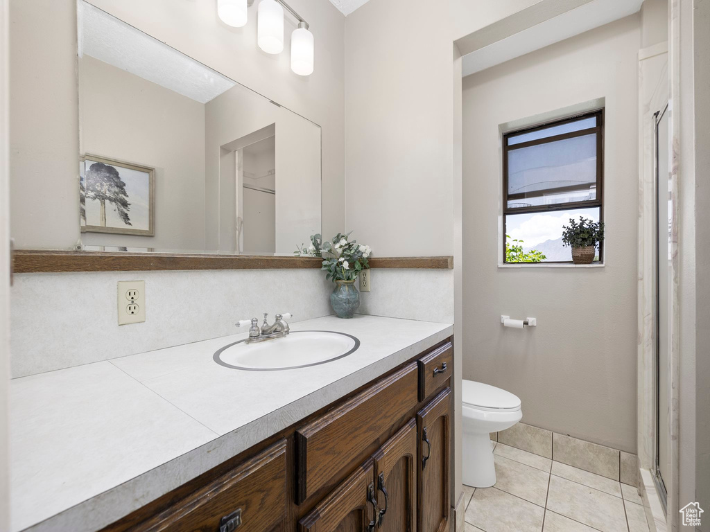 Bathroom featuring tile flooring, vanity, and toilet