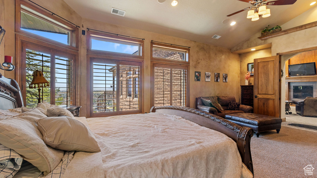 Carpeted bedroom featuring ceiling fan, access to exterior, and high vaulted ceiling