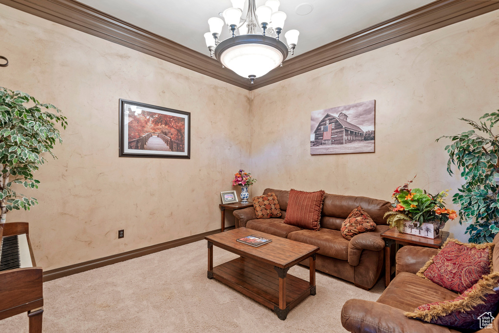 Living room featuring crown molding, carpet, and an inviting chandelier