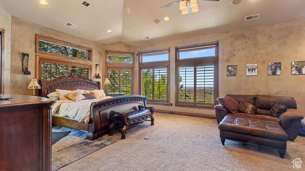 Bedroom featuring ceiling fan, light colored carpet, and lofted ceiling