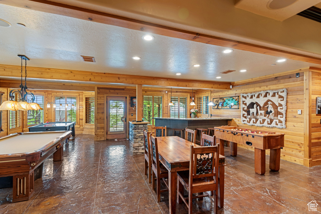 Rec room with indoor bar, a textured ceiling, wood walls, and pool table