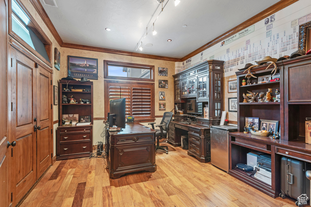 Home office with light hardwood / wood-style floors, crown molding, and rail lighting