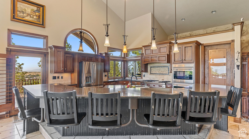 Kitchen with a spacious island, stainless steel appliances, and light tile patterned floors