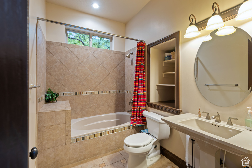 Bathroom with tile floors, toilet, and shower / tub combo