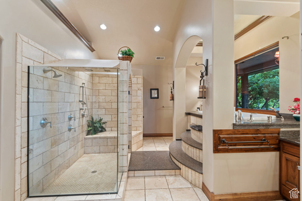 Bathroom featuring tile flooring, walk in shower, ornamental molding, and vanity