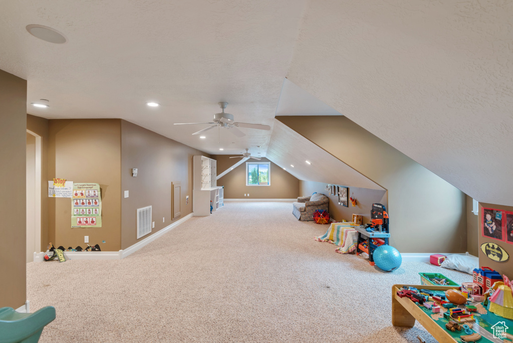 Playroom with carpet flooring, ceiling fan, a textured ceiling, and lofted ceiling